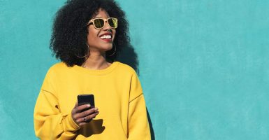 Beautiful afro american woman using mobile in the street. Communication concept.