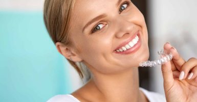 White Teeth. Closeup Portrait Of Beautiful Happy Woman With Perfect White Smile Using Teeth Whitening Tray. Smiling Girl Holding Medical Invisible Braces. Dental Health Concept. High Resolution Image
